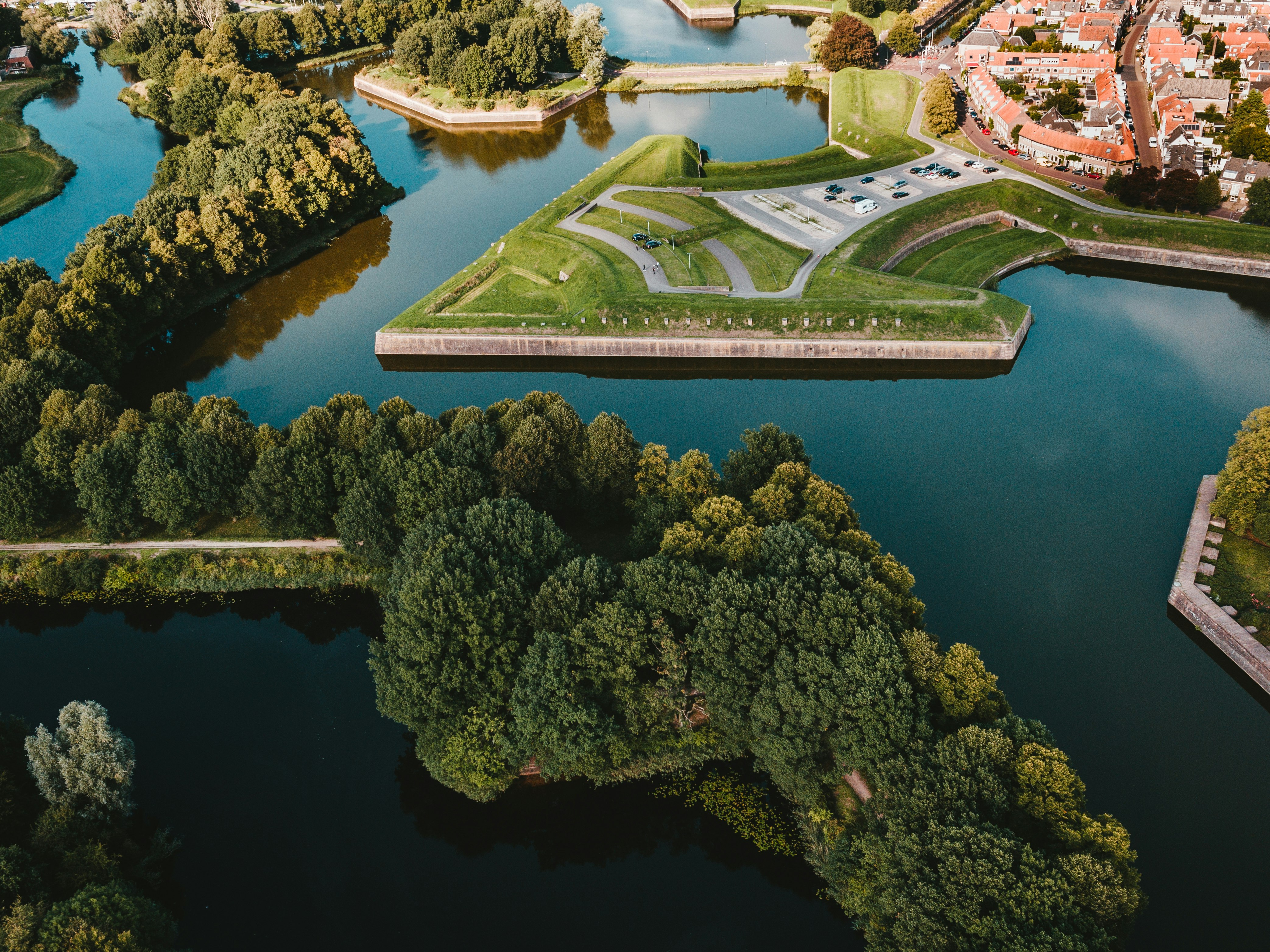 brown concrete building at center of body of water